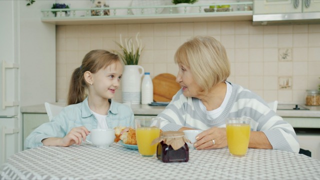 Stock photograph of models: a grandmother and granddaughter at breakfast